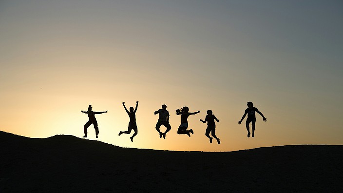 Menschen hüpfen im Sonnenuntergang