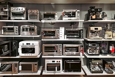 Regale mit verschiedenen Elektrogeräten und Kaffeemaschinen