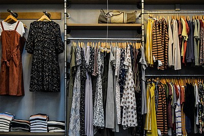 Kleiderständer und Regale mit Kleidung in einem Secondhand-Laden